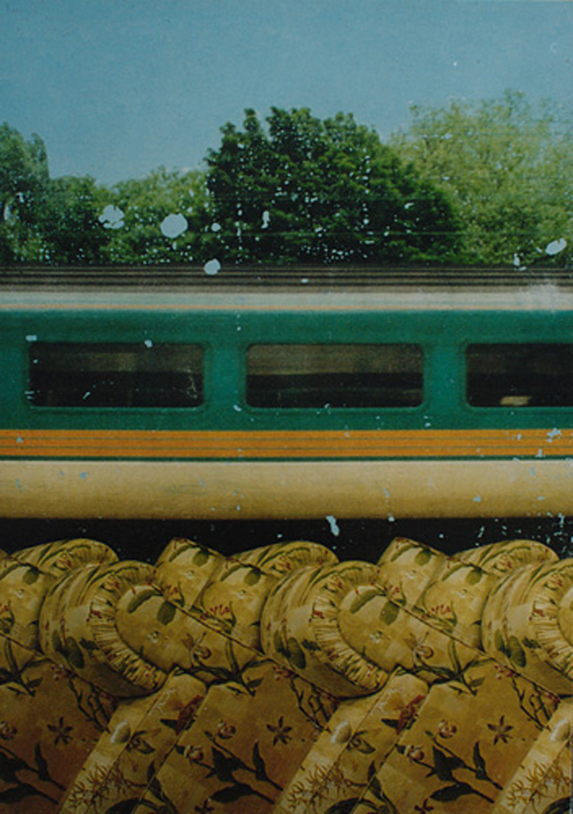 A painting of a train passing through fly-tipped sofas
